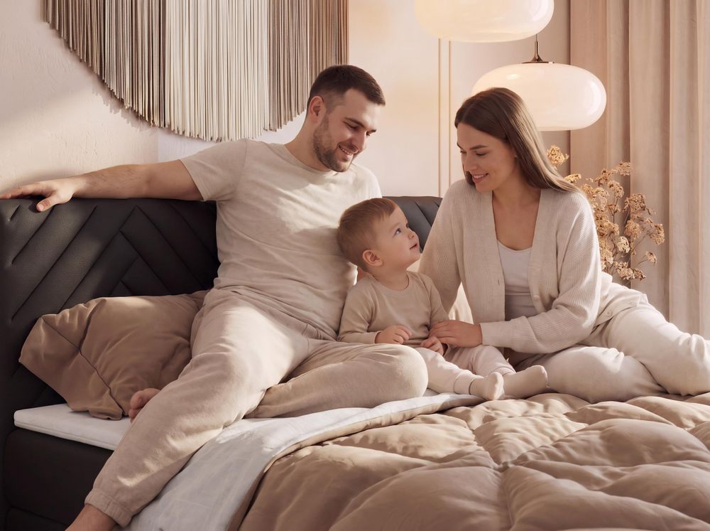 Gestepptes Kopfteil eines grau Bettes. Eine Topper-Matratze liegt auf dem Bett