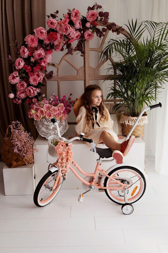 Niña sentada en la bicicleta sin ruedines, lista para pedalear sola