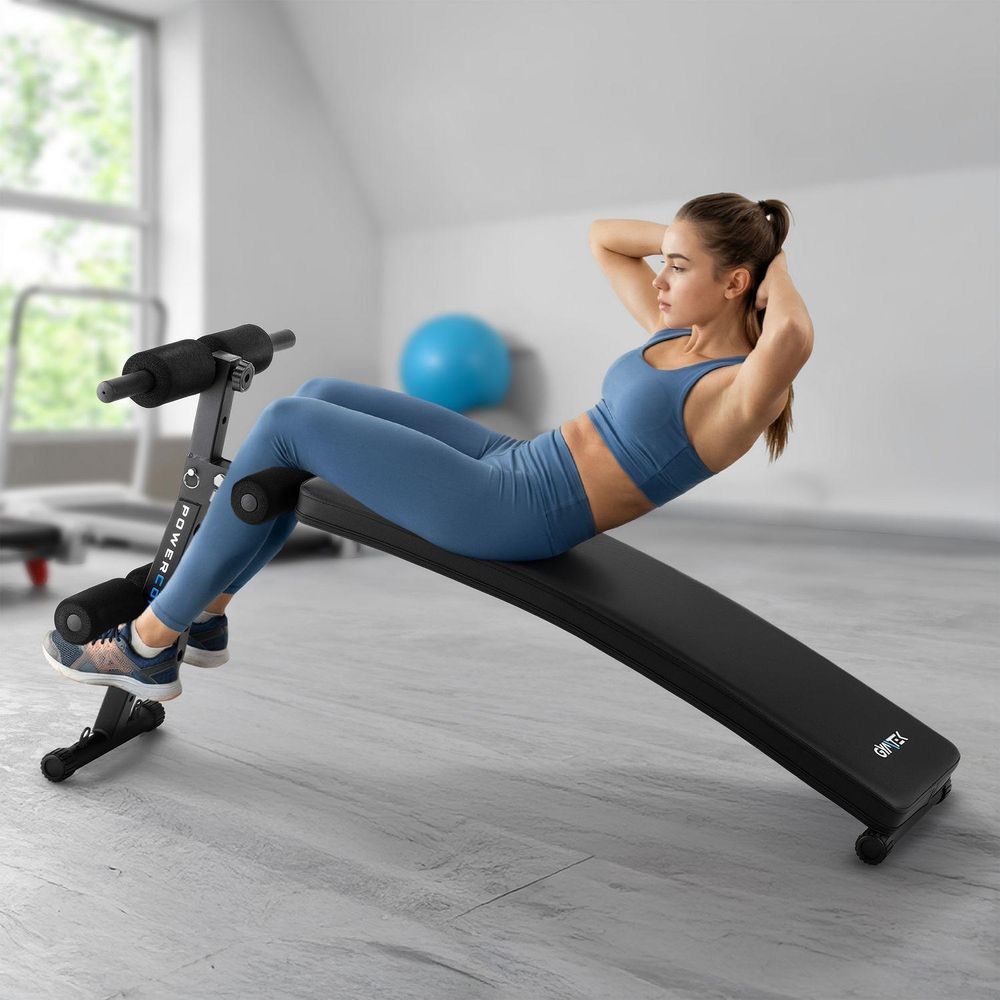 Frau trainiert Bauchmuskeln auf einer schwarzen Gymtek Schrägbank im Fitnessstudio
