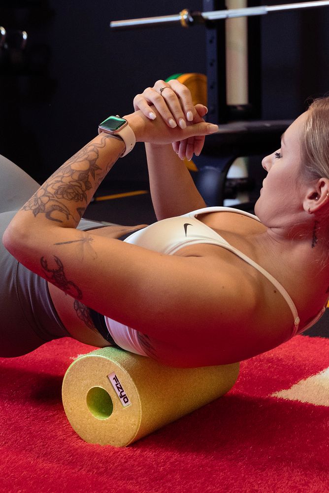 Training mit der FIZYO Massagerolle – Person führt Entspannungs- und Kräftigungsübungen durch.