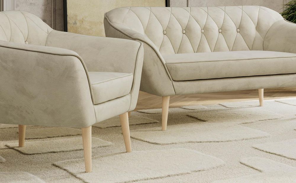 Beiges Sofa und Sessel mit gestepptem Rücken.
