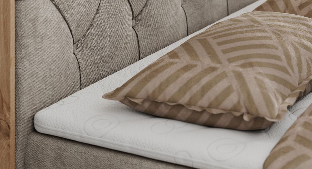 Gestepptes Kopfteil eines braun Bettes. Eine Topper-Matratze liegt auf dem Bett