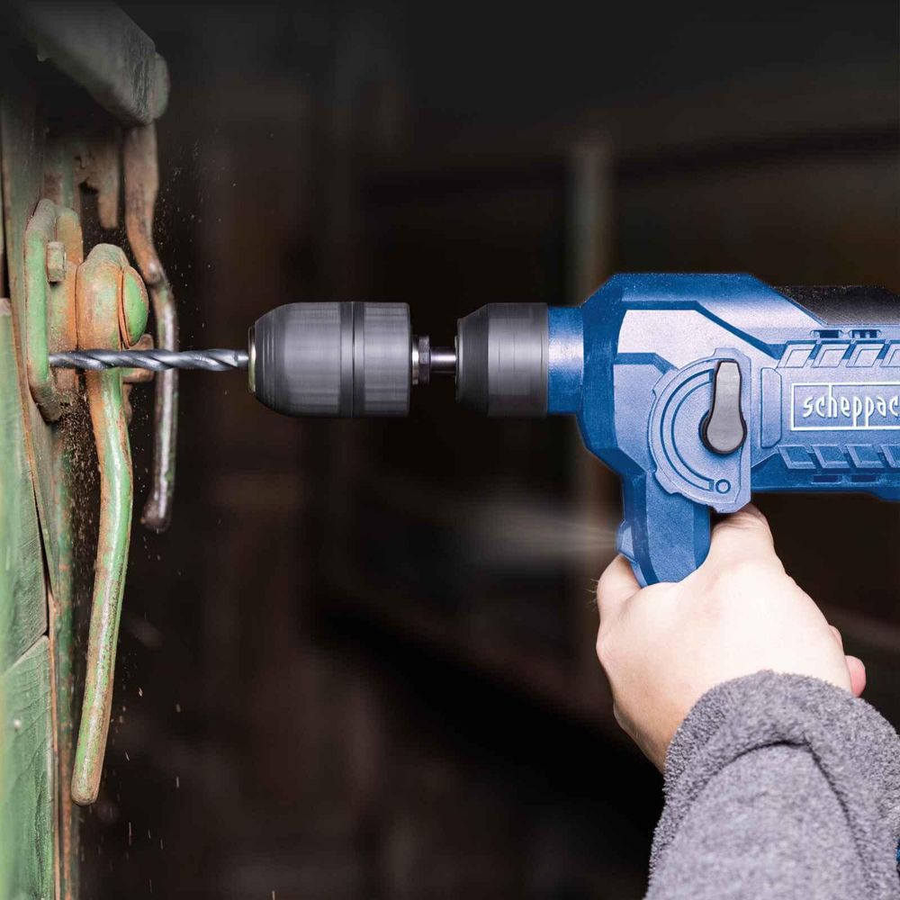 Das Bild zeigt eine Person beim Arbeiten an einer Wand mit dem Bohrhammer.