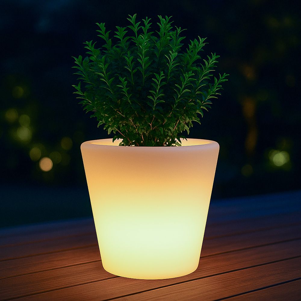 Leuchtender LED-Blumentopf, wetterfest, mit grüner Pflanze auf Holzterrasse bei Nacht.