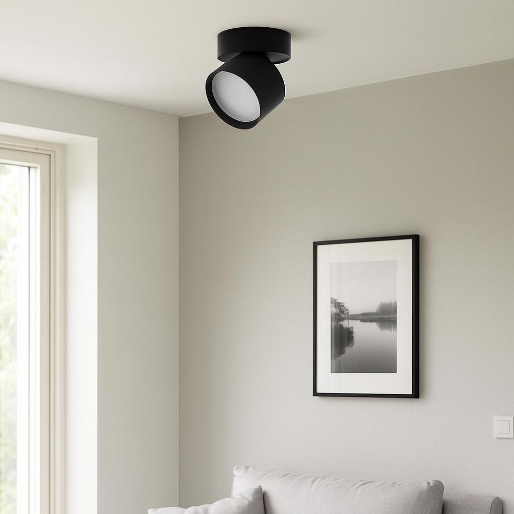 Moderne weiße Deckenleuchte mit rundem, schwenkbarem Spot in minimalistischem Wohnraum.