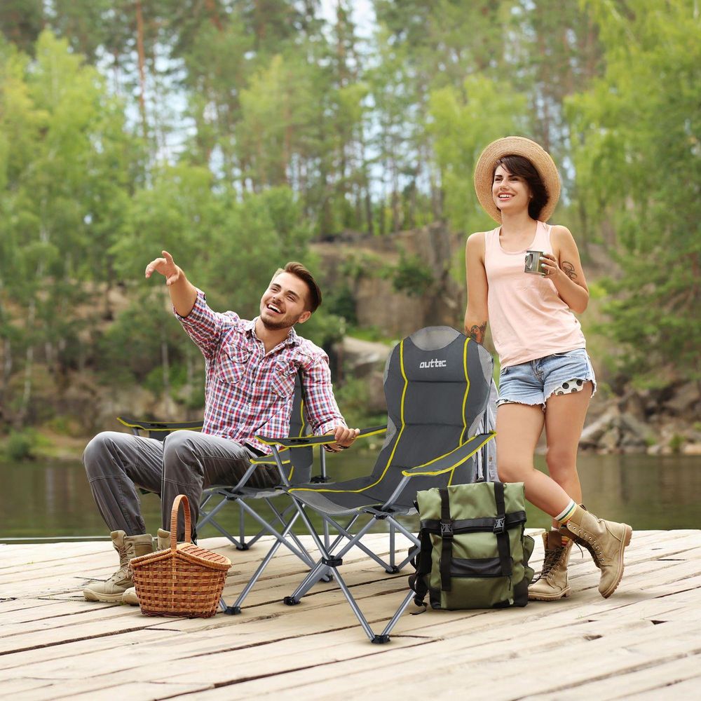 Glückliches Paar am See mit Outtec Campingstühlen, Picknickkorb und Rucksack