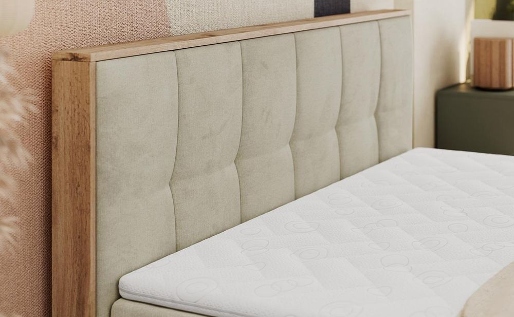 Detailansicht eines grauen Boxspringbetts mit gepolstertem Kopfteil im geometrischen Steppmuster.