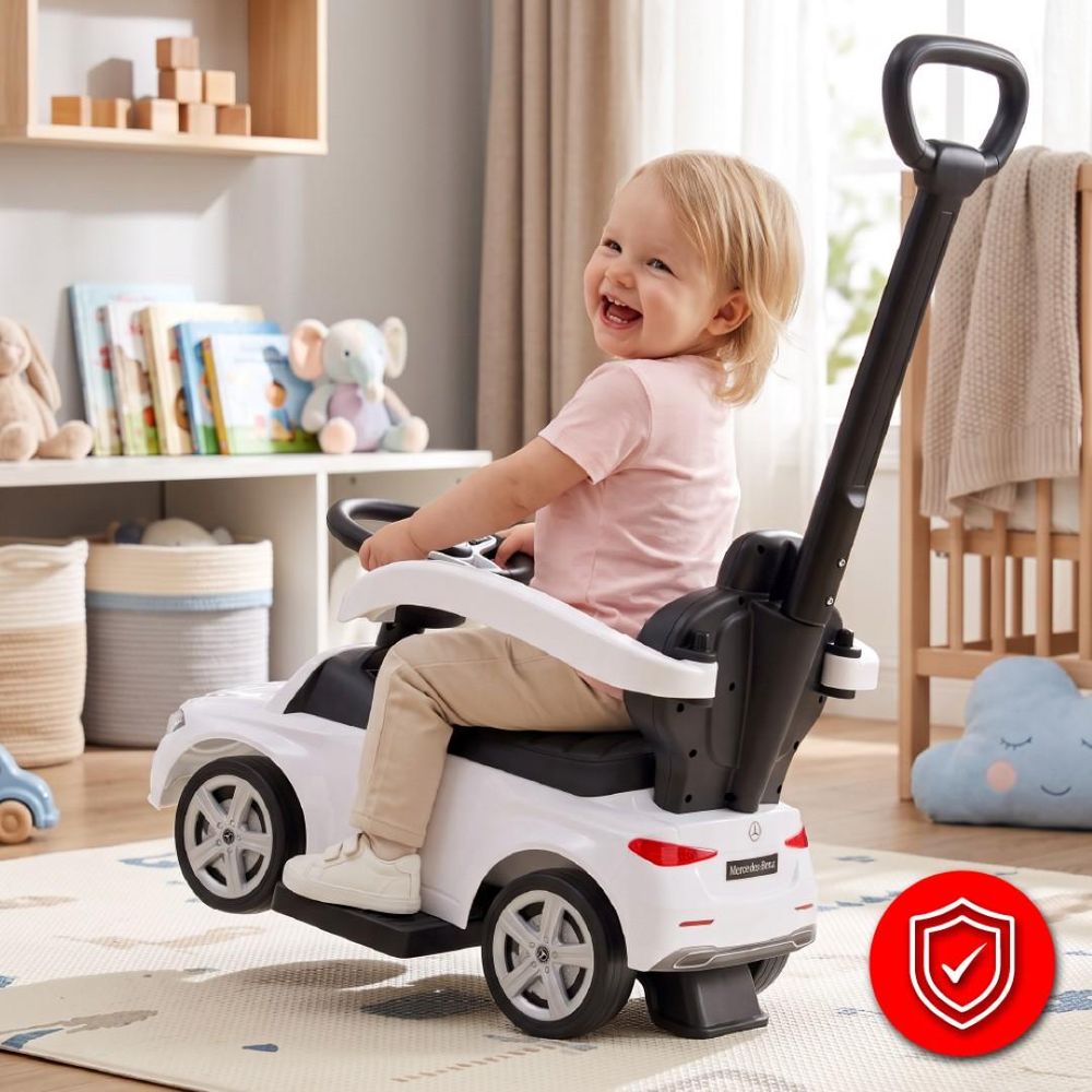 Enfant souriant sur le porteur Mercedes-Benz, poussé par un adulte à l’intérieur.
