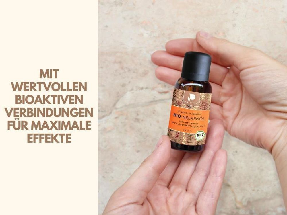 Weiße Frauenhand die das Nelkenöl in der Hand hält