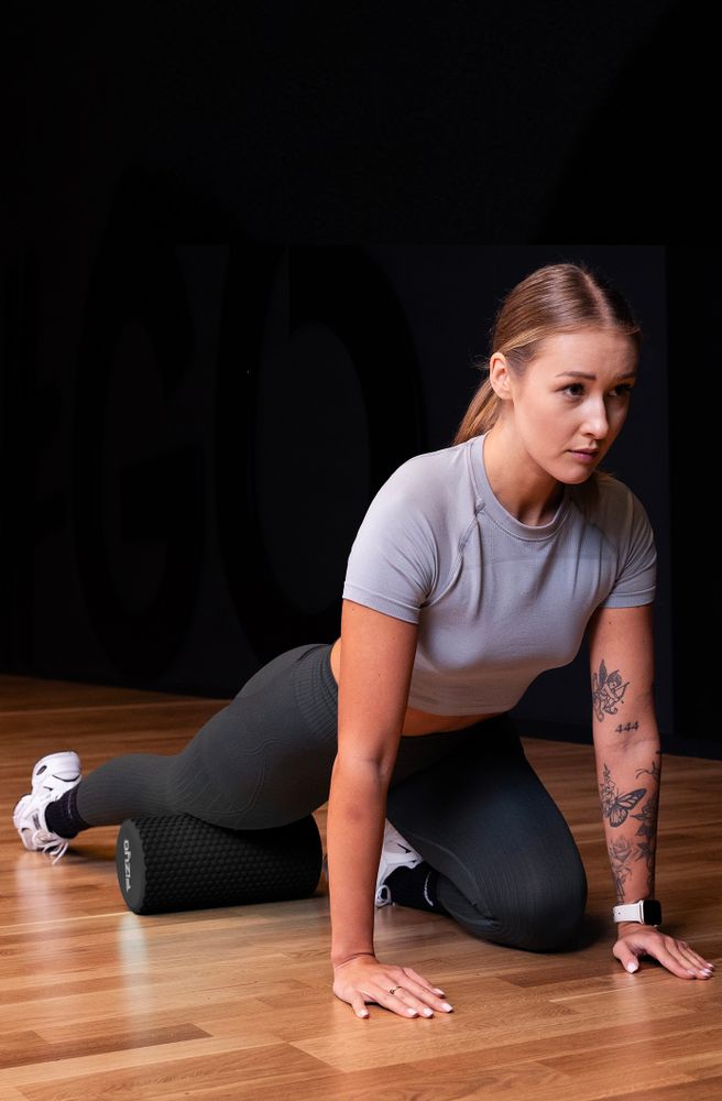 Trening Fitness z wałkiem do masażu z wypustkami 30x15 cm FIZYO — osoba wykonuje ćwiczenia