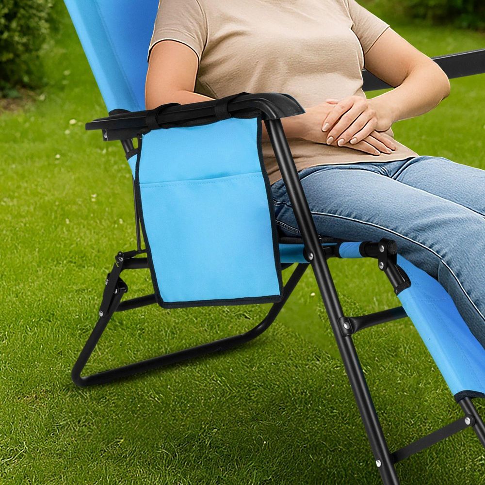Nahaufnahme der Seitentasche eines hellblauen Gartenliegestuhls auf Rasen
