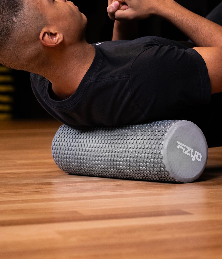 Fitness-Training mit einer Noppen-Massagerolle 45x15 cm FIZYO – eine Person führt Übungen aus