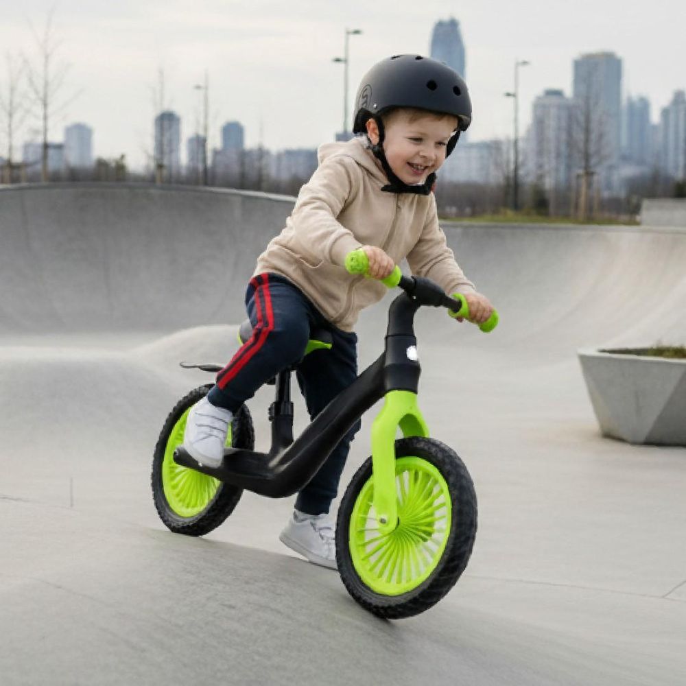 Niño montando la bicicleta Sun Baby Sport en un parque urbano.