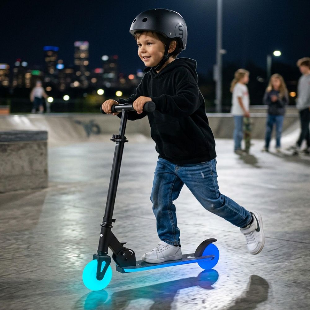 Kind fährt Tretroller mit leuchtenden Rädern im Skatepark