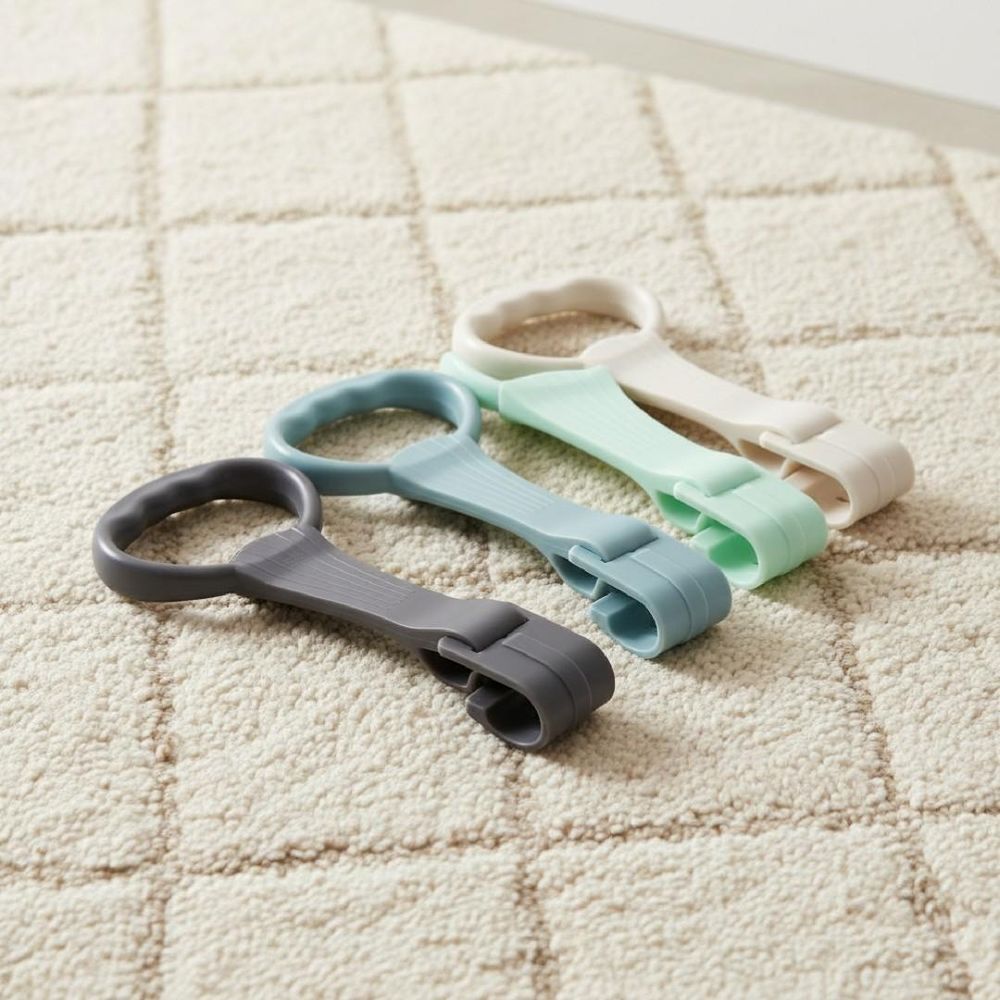 Quatre poignées TPE colorées posées sur un tapis.