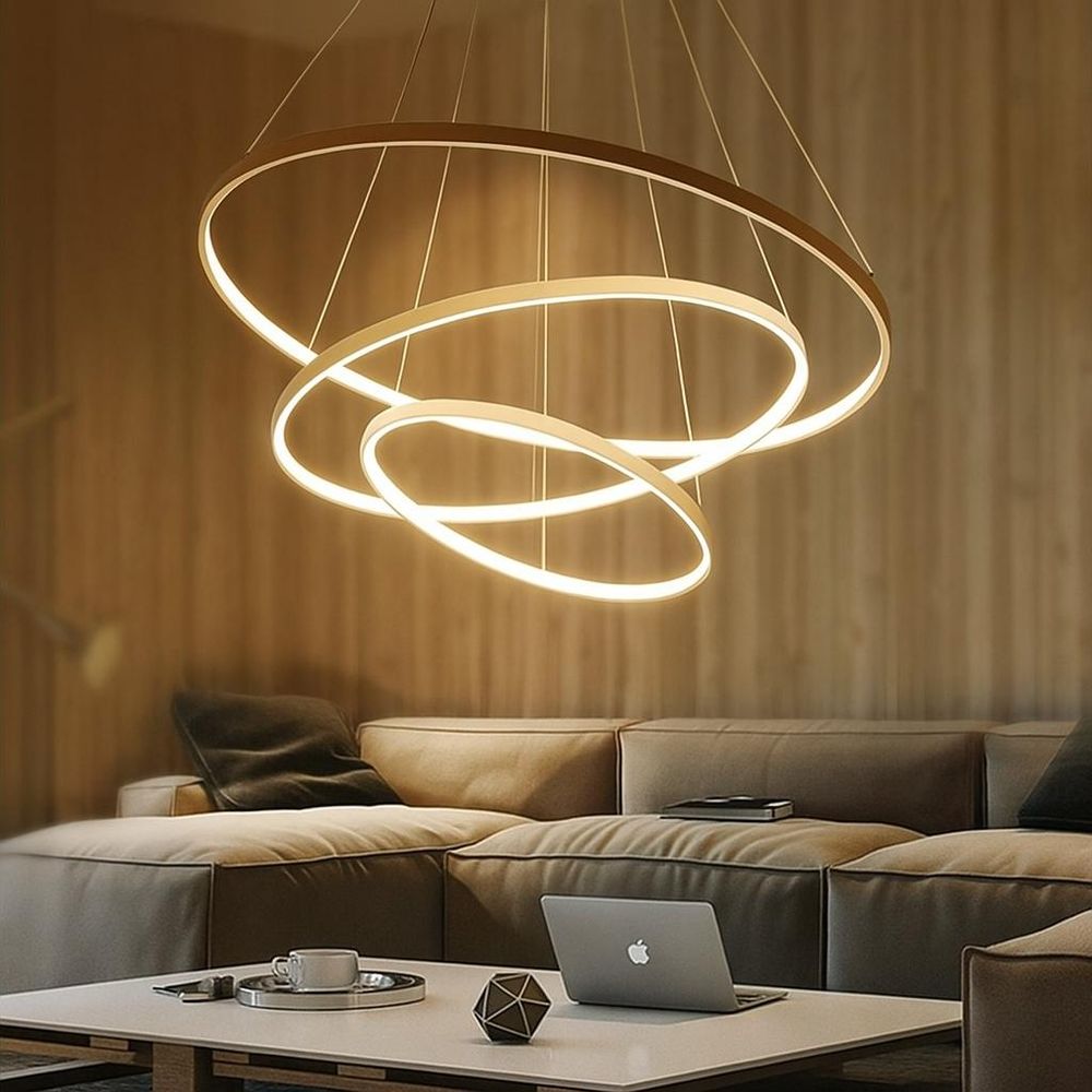 Goldene LED-Hängeleuchte Hodo über modernem Sofa in warm beleuchtetem Wohnzimmer