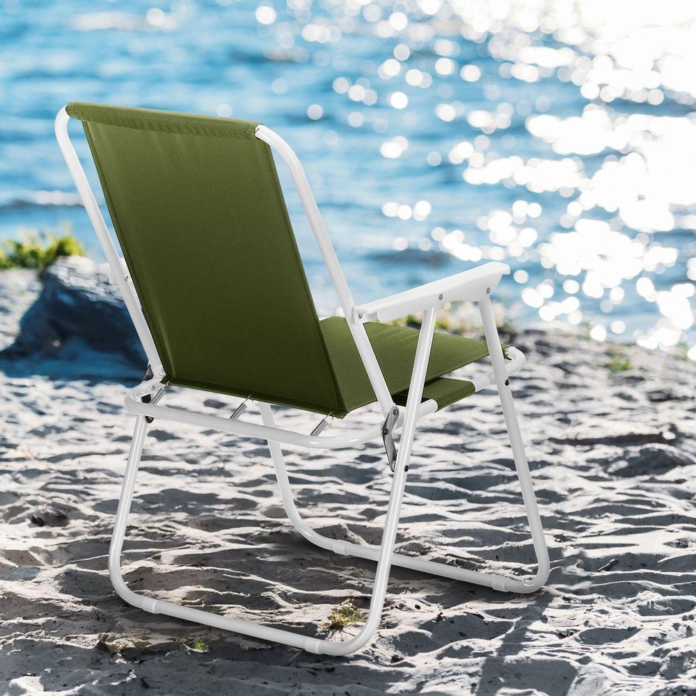 Leerer Klappstuhl auf sandigem Strand mit Blick aufs Meer, bereit zum Entspannen