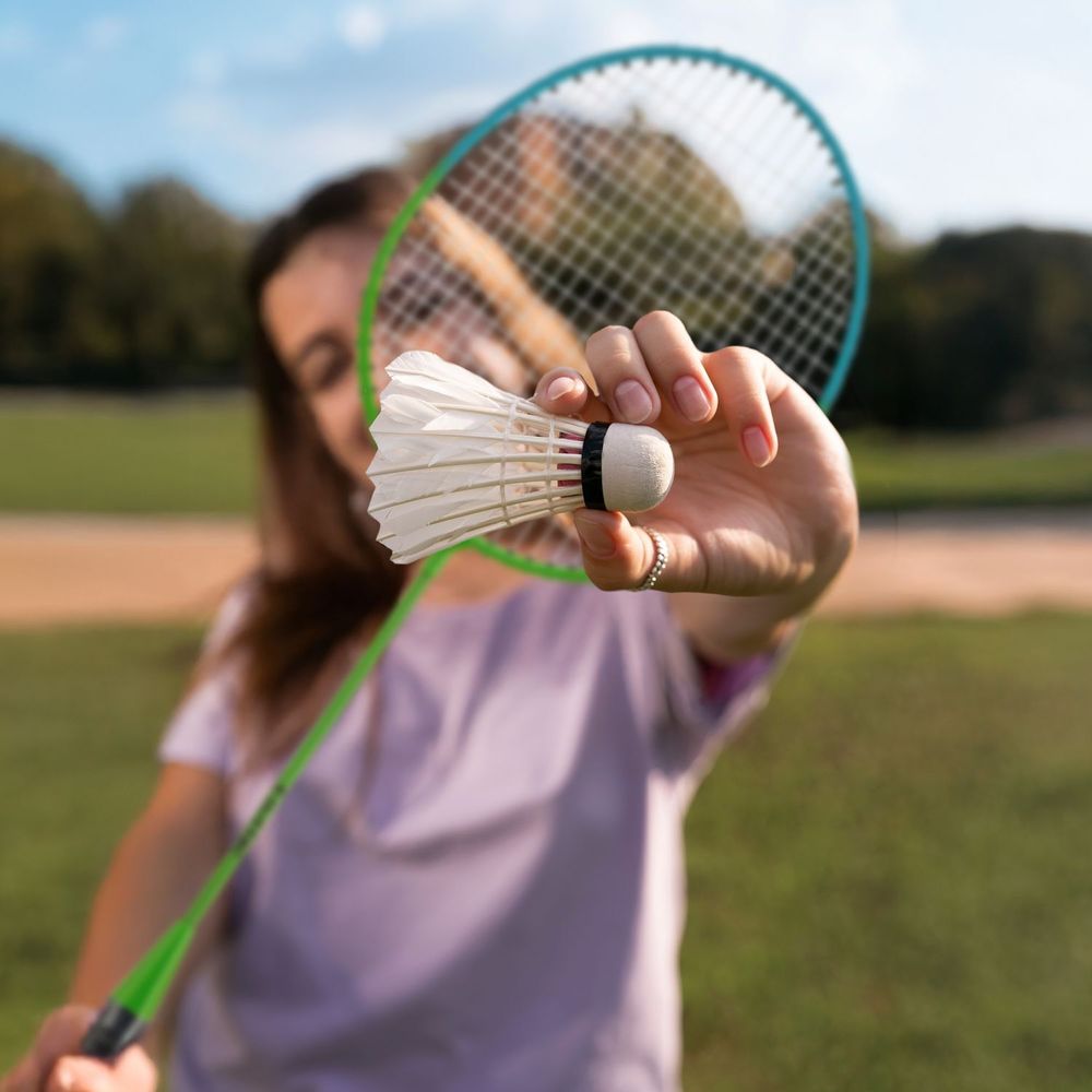 Frau hält einen Badminton-Federball in der Hand.