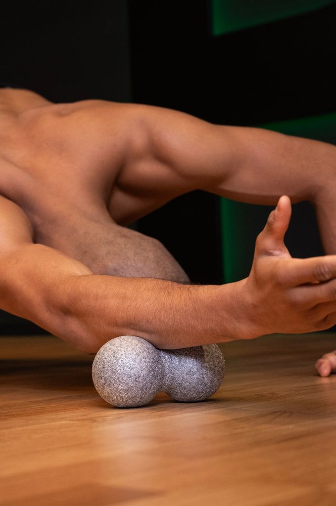 Osoba ćwicząca i wykorzystująca piłkę do masażu duoball FIZYO 16x8 cm