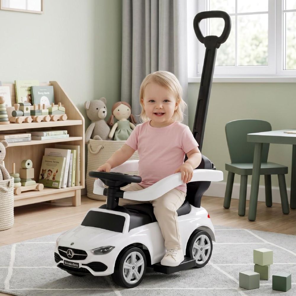Enfant assis sur le porteur Mercedes-Benz blanc dans un salon.