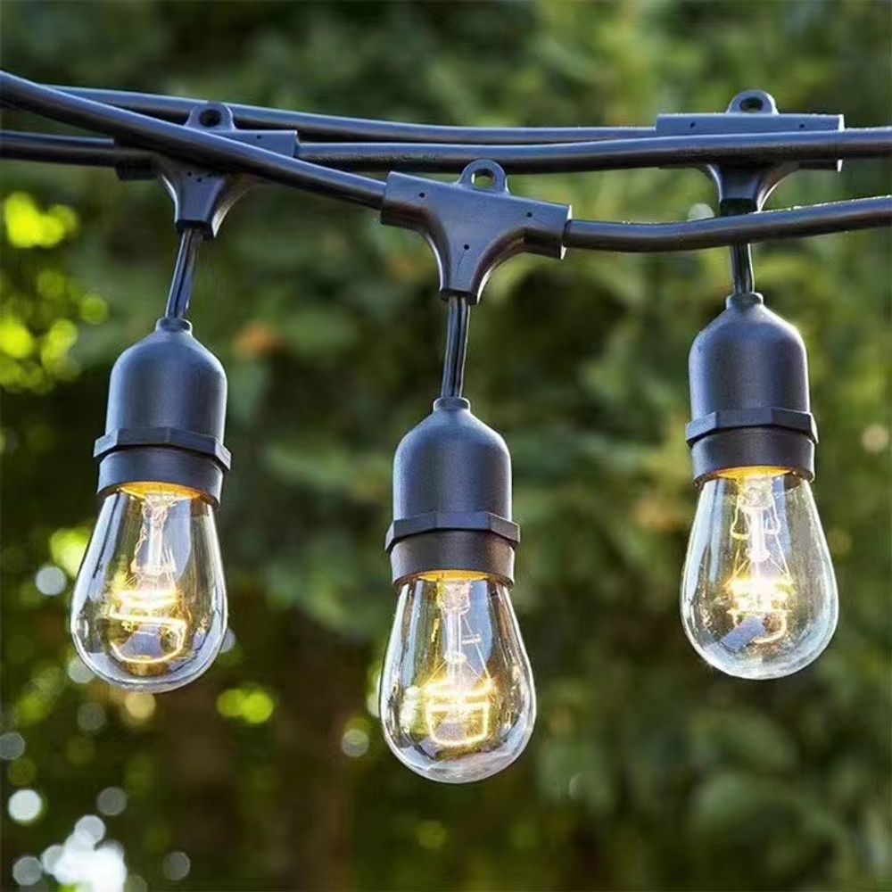 Sichere 24V Beleuchtung, drei hängende LED-Glühbirnen vor grünem Hintergrund.