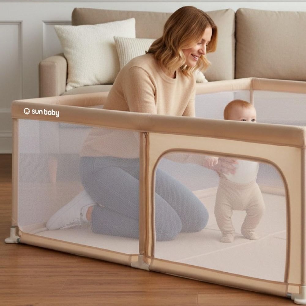 Moeder en baby bij de kinderbox, baby staat veilig binnen