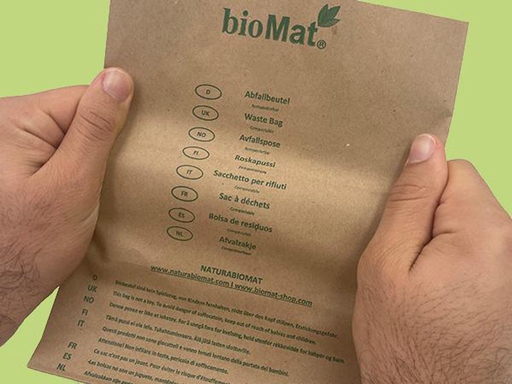 Das Bild zeigt den braunen bioMat Papiersack, und zwei Hände die diesen Sack auseinander ziehen.