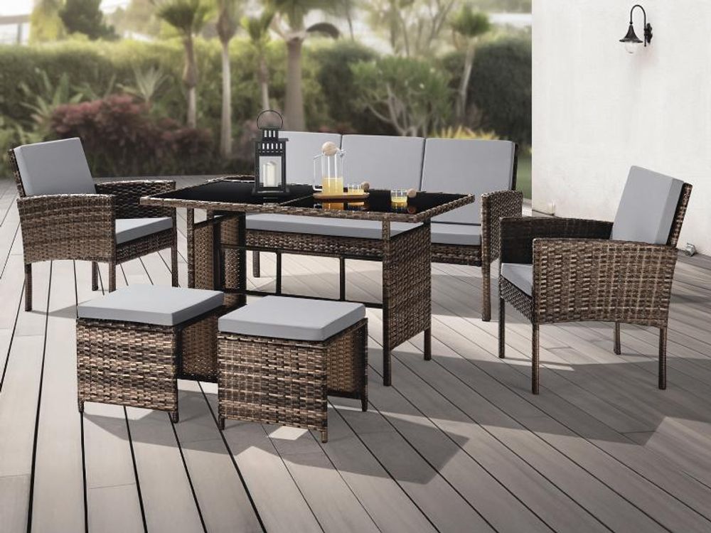 Das Rattanset DENVER auf einer Terrasse, im Hintergrund ein tropischer Garten.