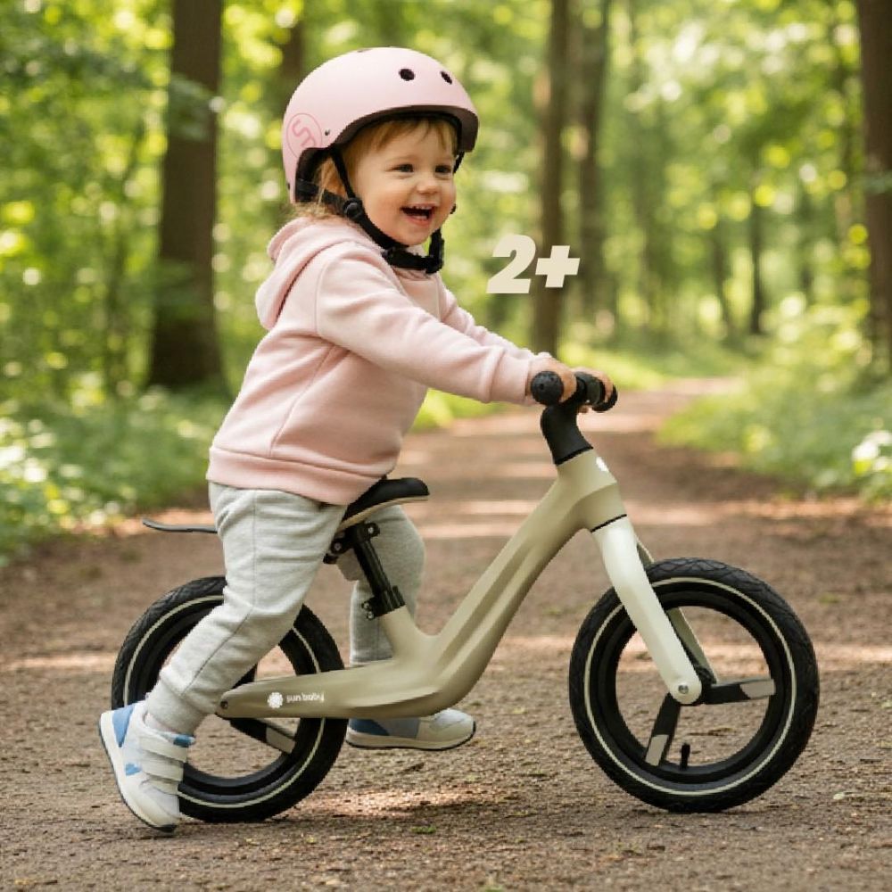 Dziecko na rowerku Sun Baby SPORT 12" podczas jazdy w parku, oznaczenie 2+.