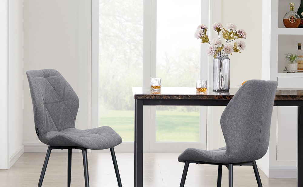 Das Bild zeigt einen Tisch mit zwei Stühlen und einer Vase.