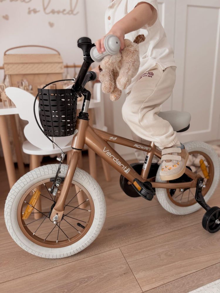 Cesta delantera negra en la bicicleta infantil, con peluche dentro.