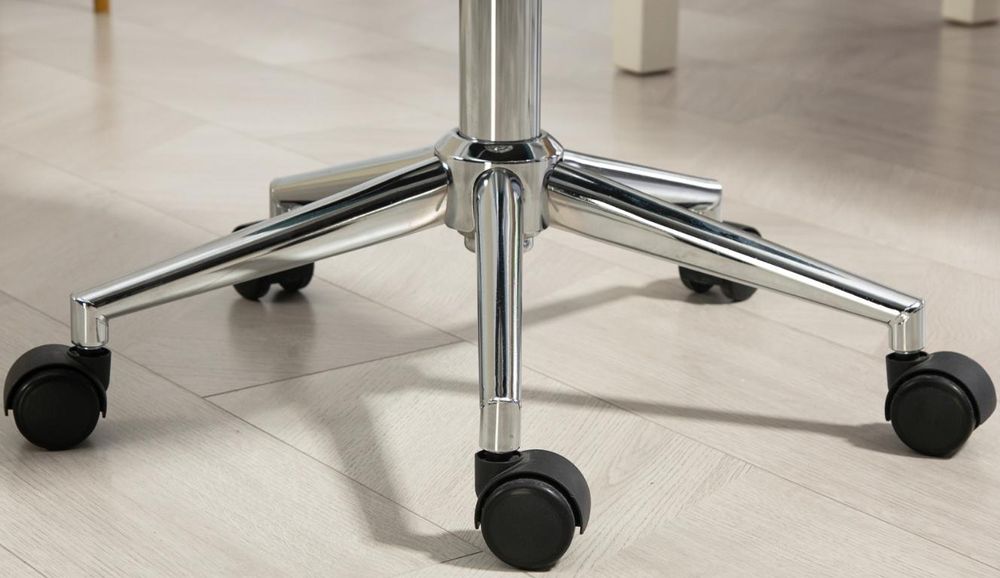 Untergestell eines Bürostuhls mit fünf Rollen und Metallbeinen auf einem glatten Boden.