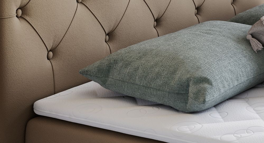Gestepptes Kopfteil eines braun Bettes. Eine Topper-Matratze liegt auf dem Bett