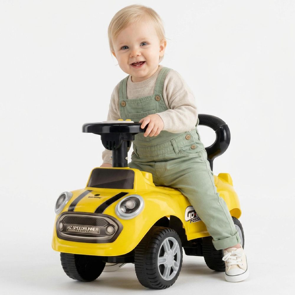 Kind hält das Lenkrad des gelben Rutschautos und lächelt
