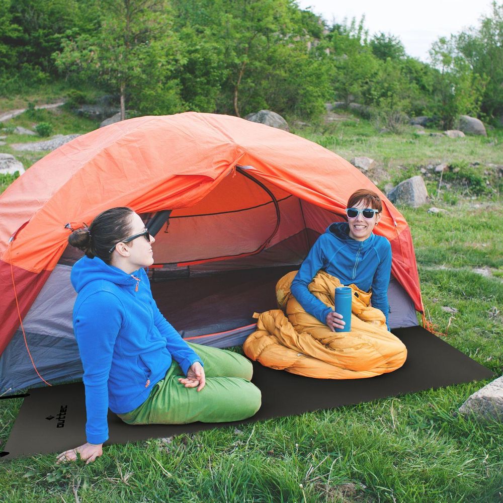 Zwei Frauen sitzen auf Outtec Isomatten vor Zelt beim Camping. Komfort in der Natur