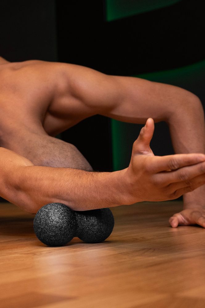 Osoba ćwicząca i wykorzystująca piłkę do masażu duoball FIZYO 16x8 cm