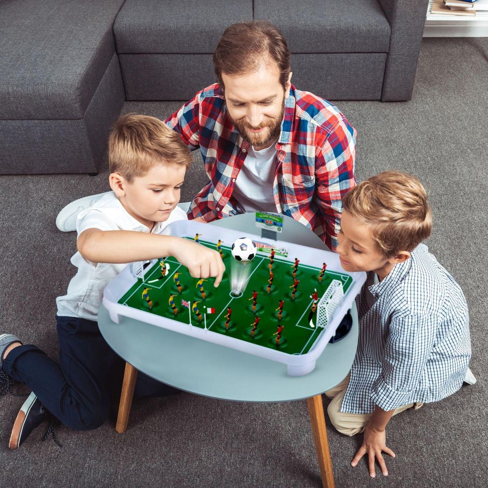 Vater und Söhne spielen begeistert Tischfußball