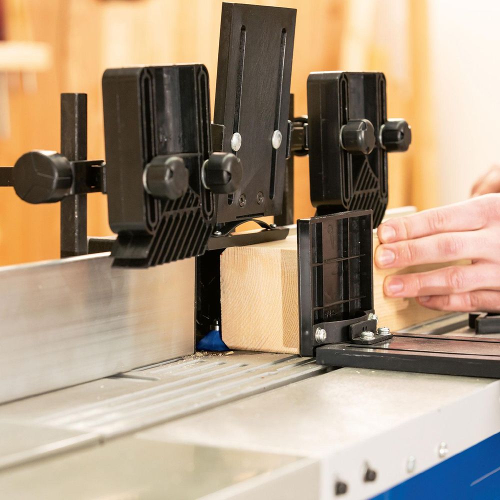 Das Bild zeigt eine Person bei der Arbeit mit der Holzfräse.