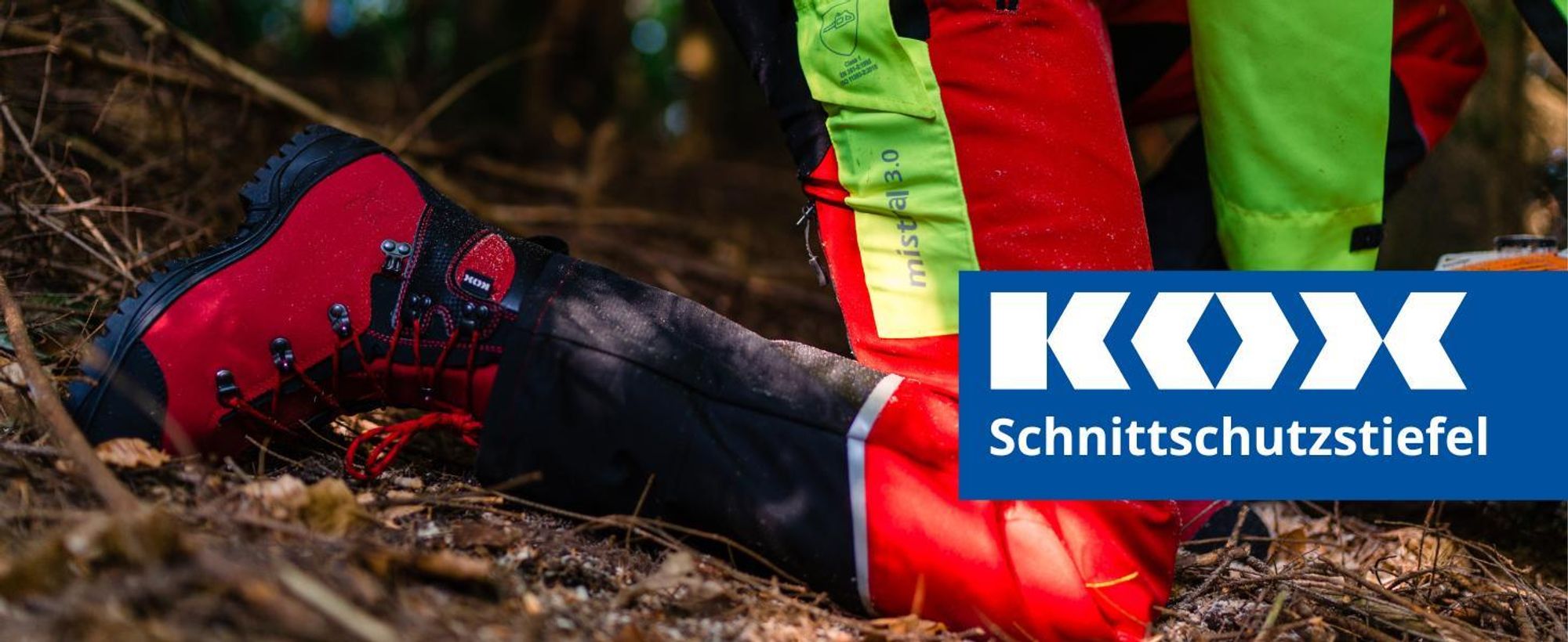 Das Bild zeigt einen KOX Schnittschutzstiefl auf einem Baumstamm und eine Motorsäge