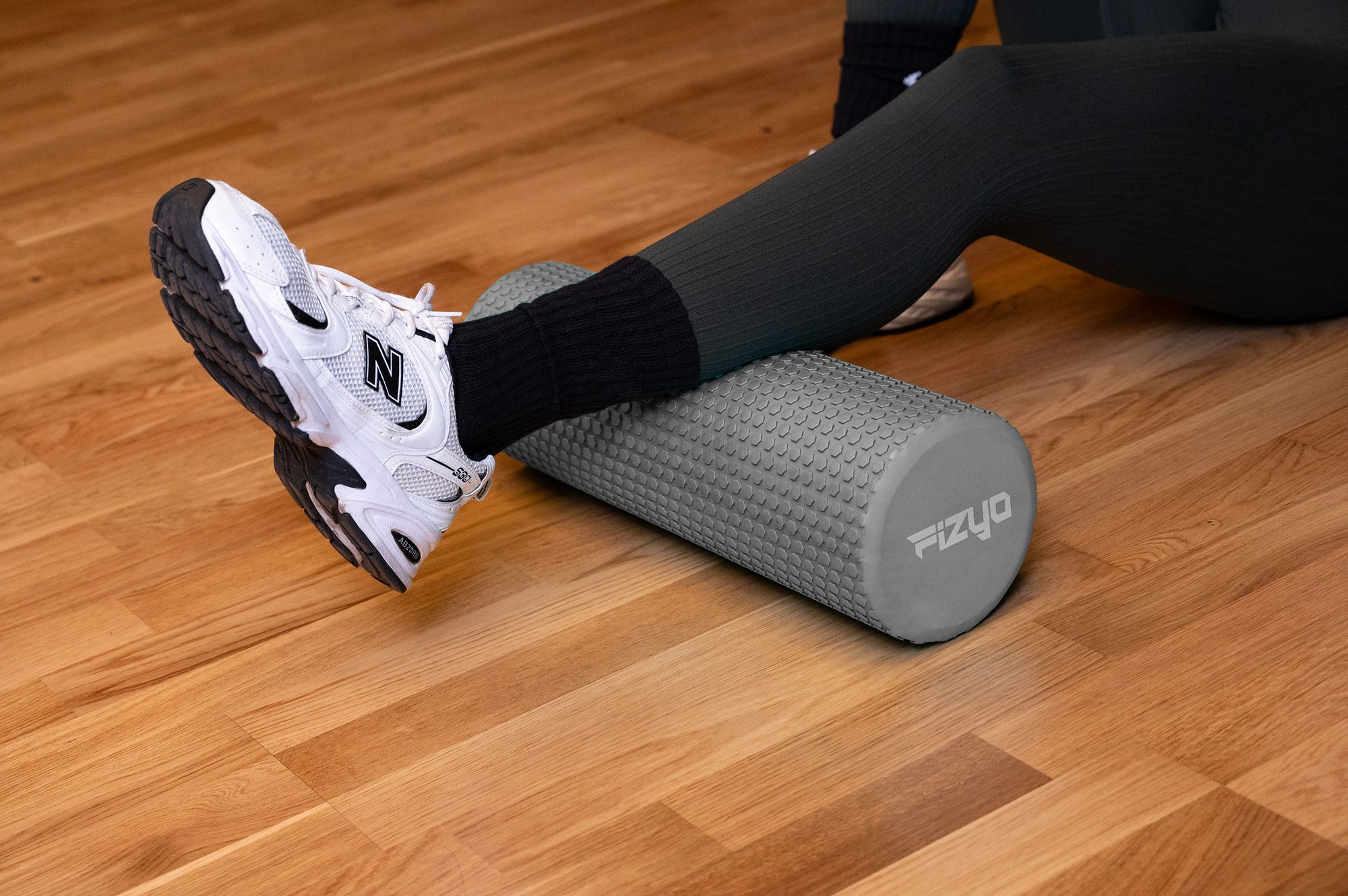 Fitness-Training mit einer Noppen-Massagerolle 45x15 cm FIZYO – eine Person führt Übungen aus