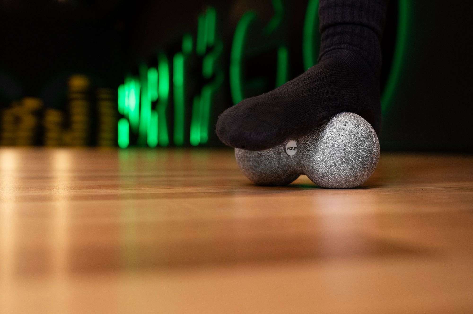 Osoba ćwicząca i wykorzystująca piłkę do masażu duoball FIZYO 16x8 cm