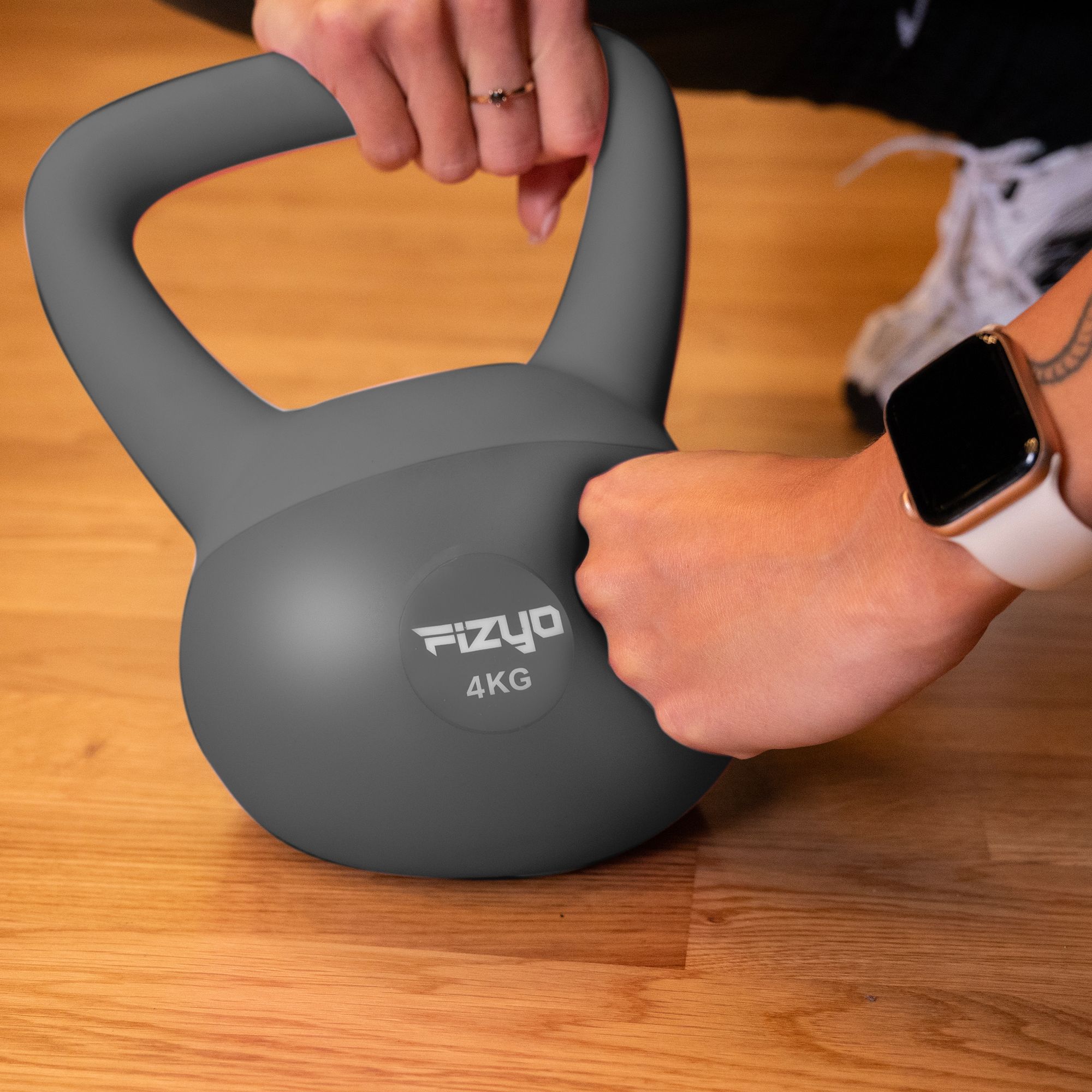 Osoba ćwiczy przy pomocy ciężarka hantla miękki kettlebell FIZYO