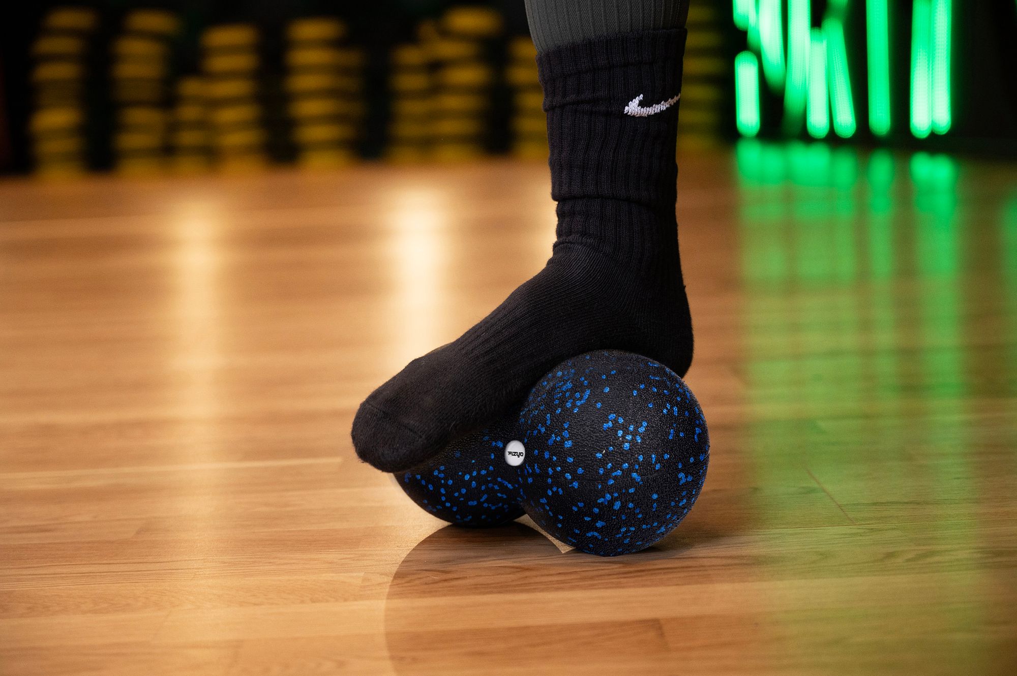 Osoba ćwicząca i wykorzystująca piłkę do masażu duoball FIZYO 24x12 cm