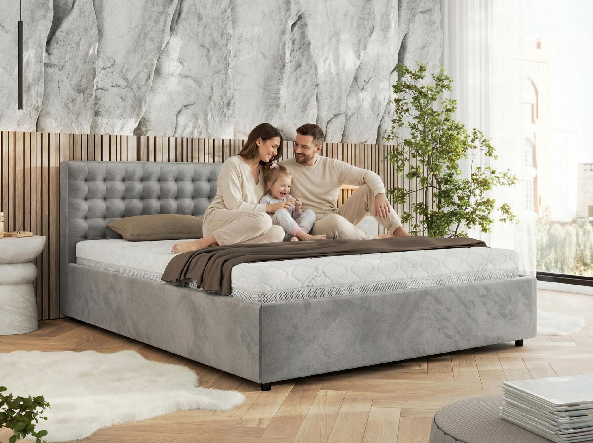 Familie sitzt auf beigem Polsterbett in elegantem Schlafzimmer.