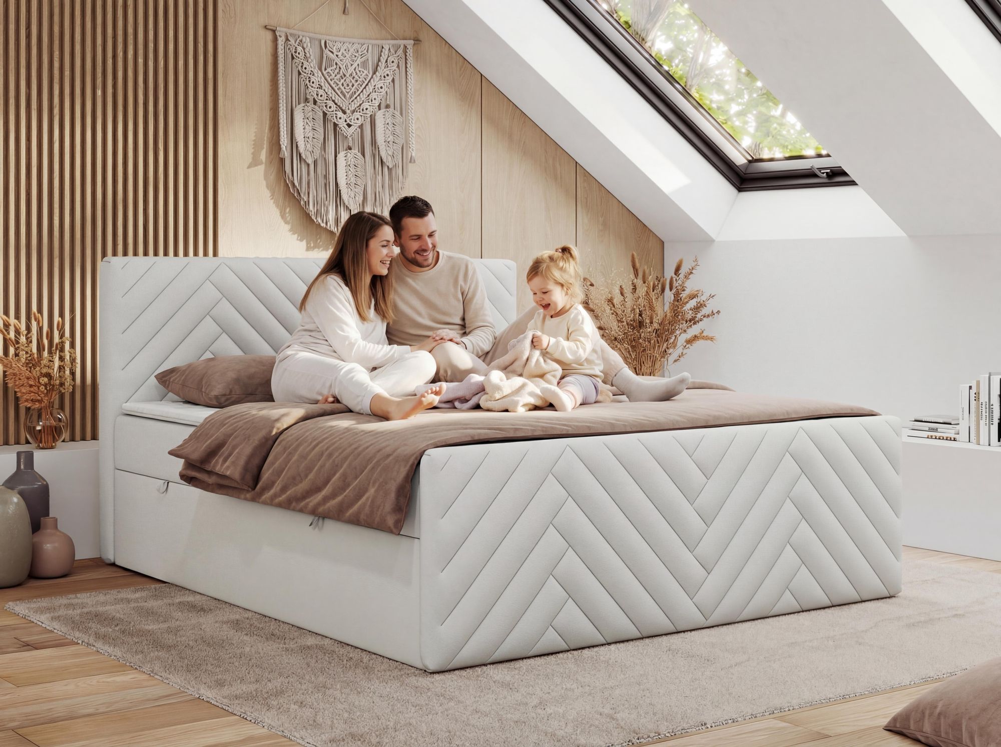 Familie entspannt auf weiss Boxspringbett im hellen Schlafzimmer.