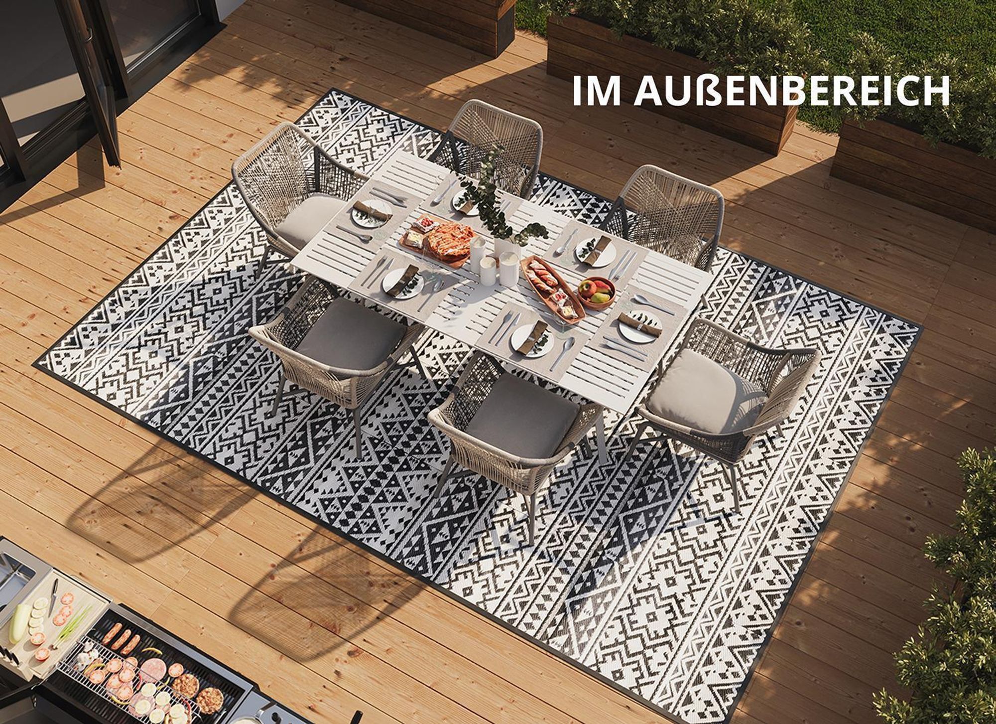 Esstisch auf grau-weißem Outdoor-Teppich.