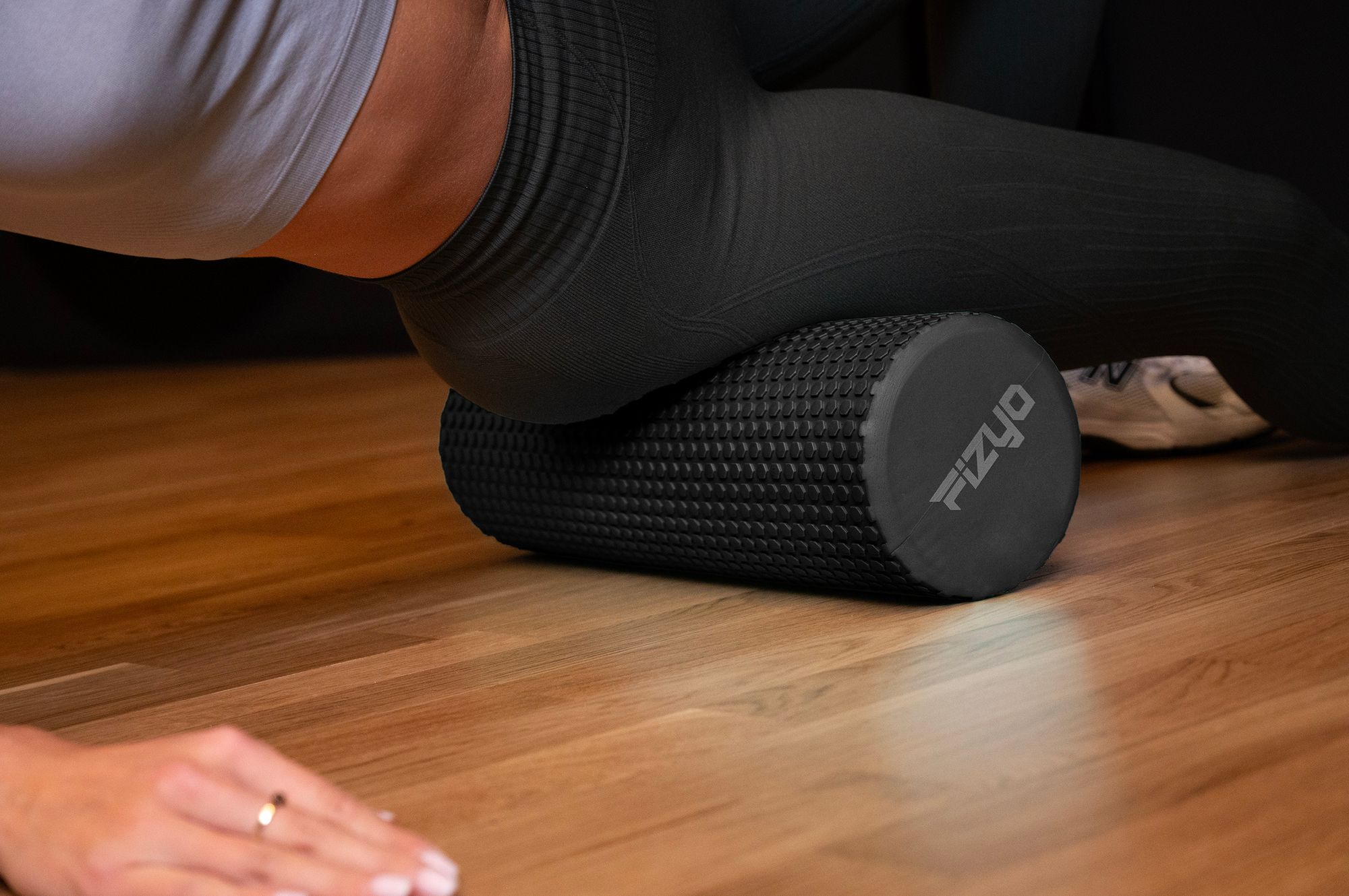 Trening Fitness z wałkiem do masażu z wypustkami 45x15 cm FIZYO — osoba wykonuje ćwiczenia