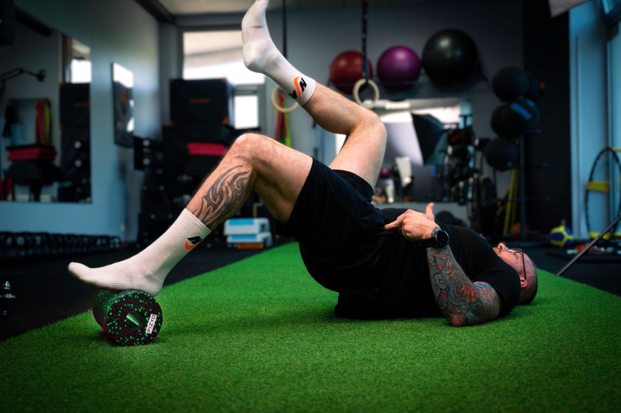 Training mit der FIZYO Massagerolle – Person führt Entspannungs- und Kräftigungsübungen durch.