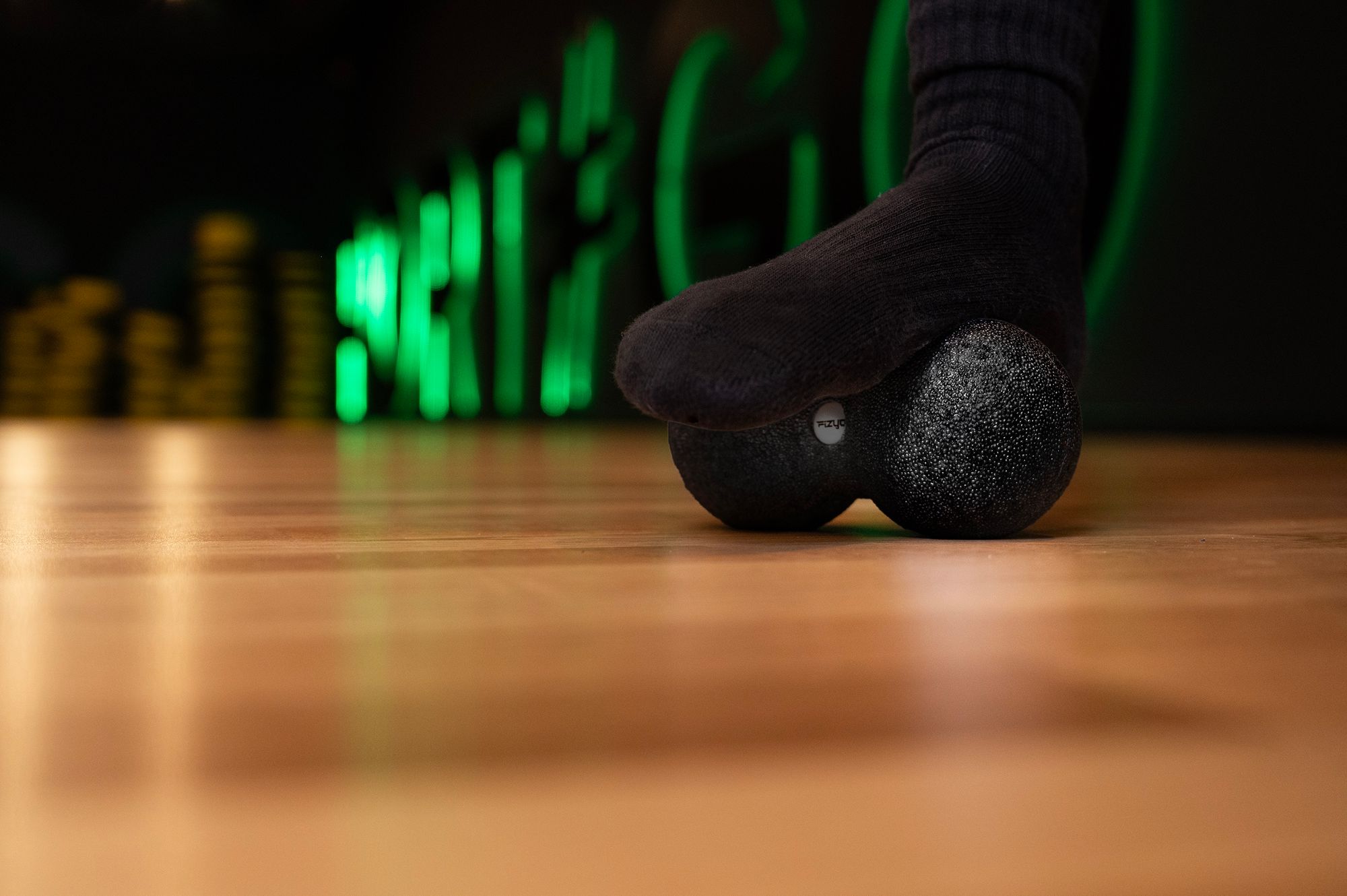 Osoba ćwicząca i wykorzystująca piłkę do masażu duoball FIZYO 16x8 cm
