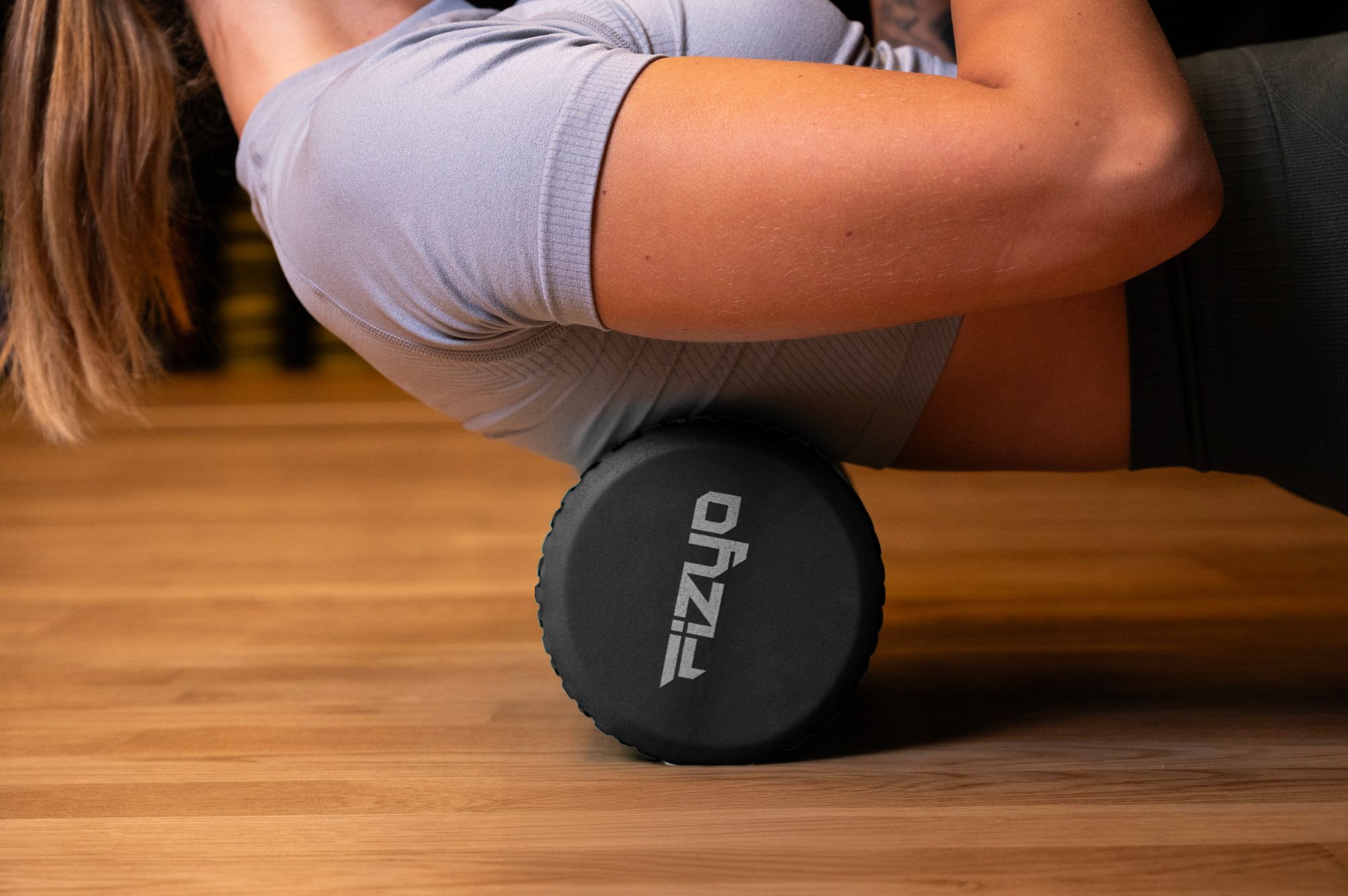 Trening Fitness z wałkiem do masażu z wypustkami 45x15 cm FIZYO — osoba wykonuje ćwiczenia